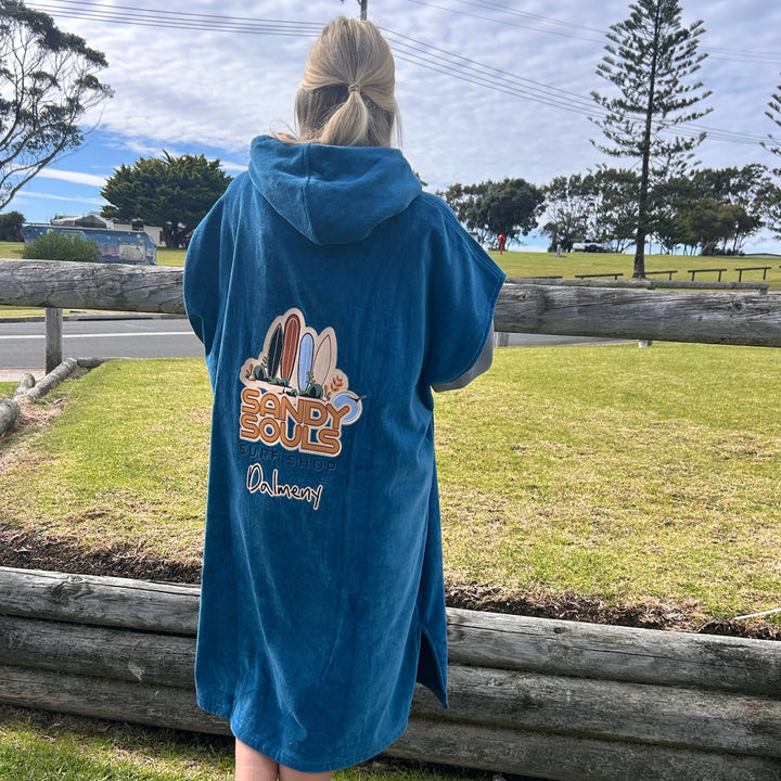 Person wearing a blue towel with text and graphics on a grassy area