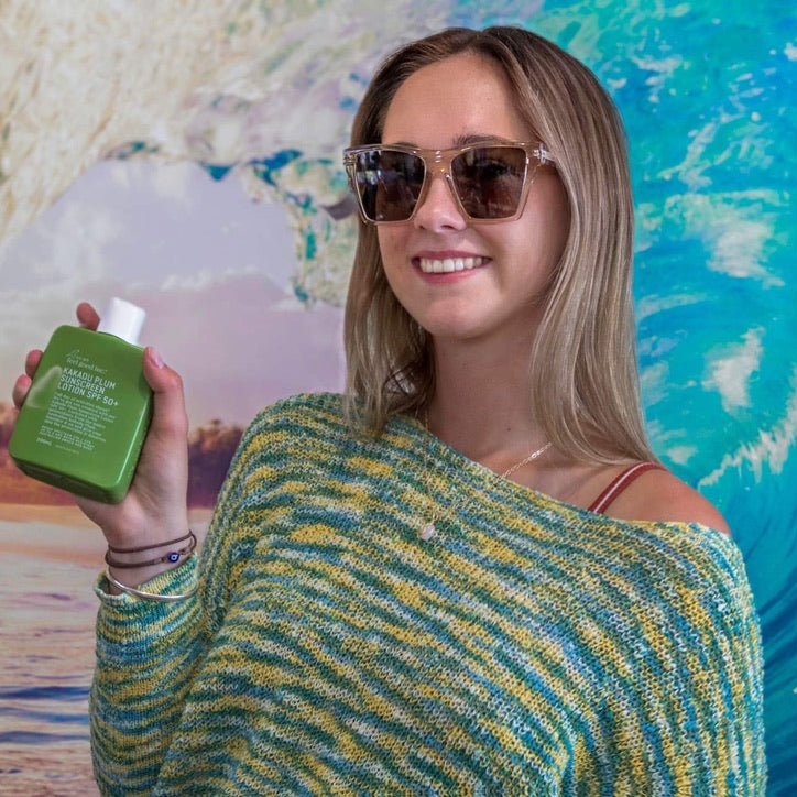 Woman holding a green bottle against a colorful abstract background