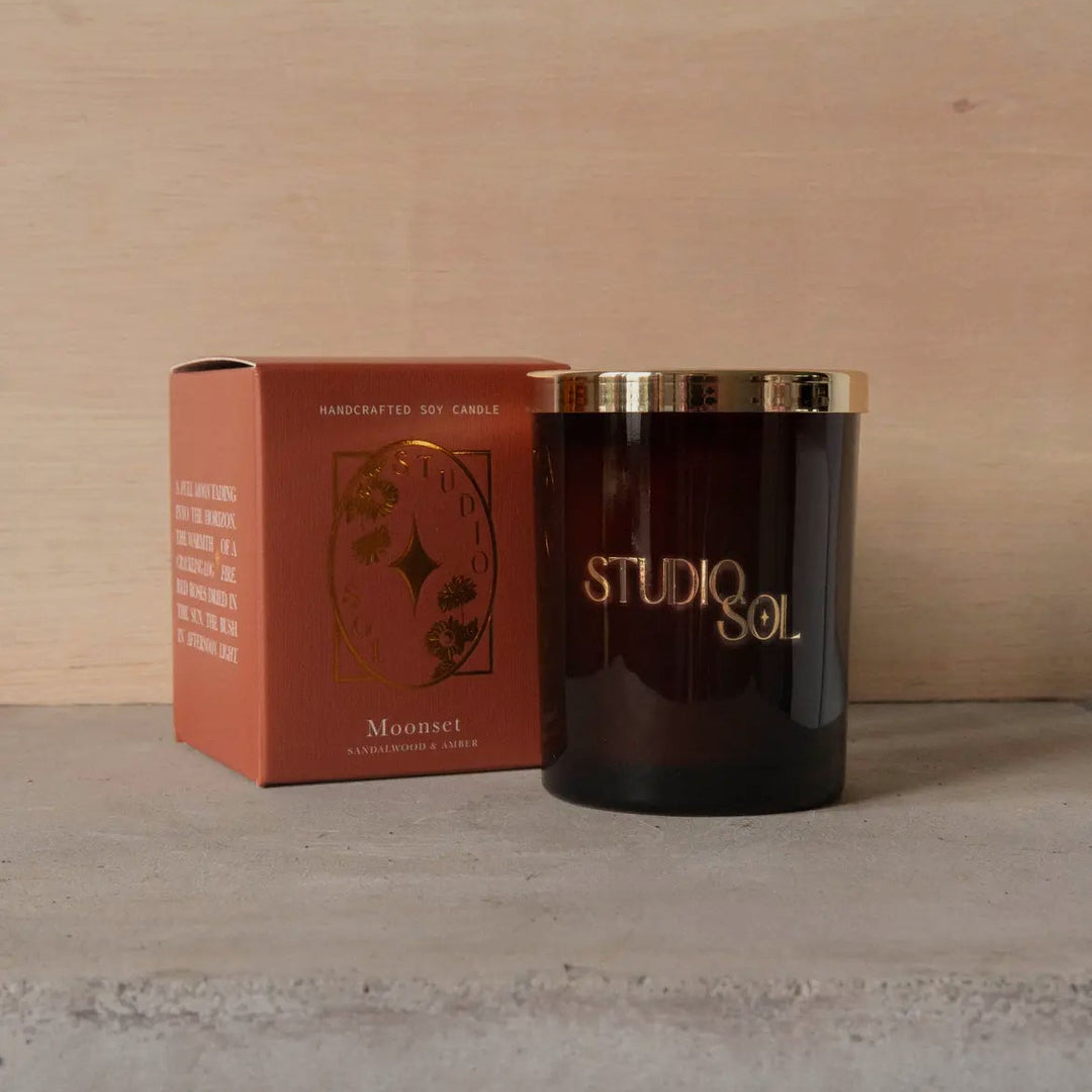 Candle and packaging with 'Studio Sol' branding on a neutral background