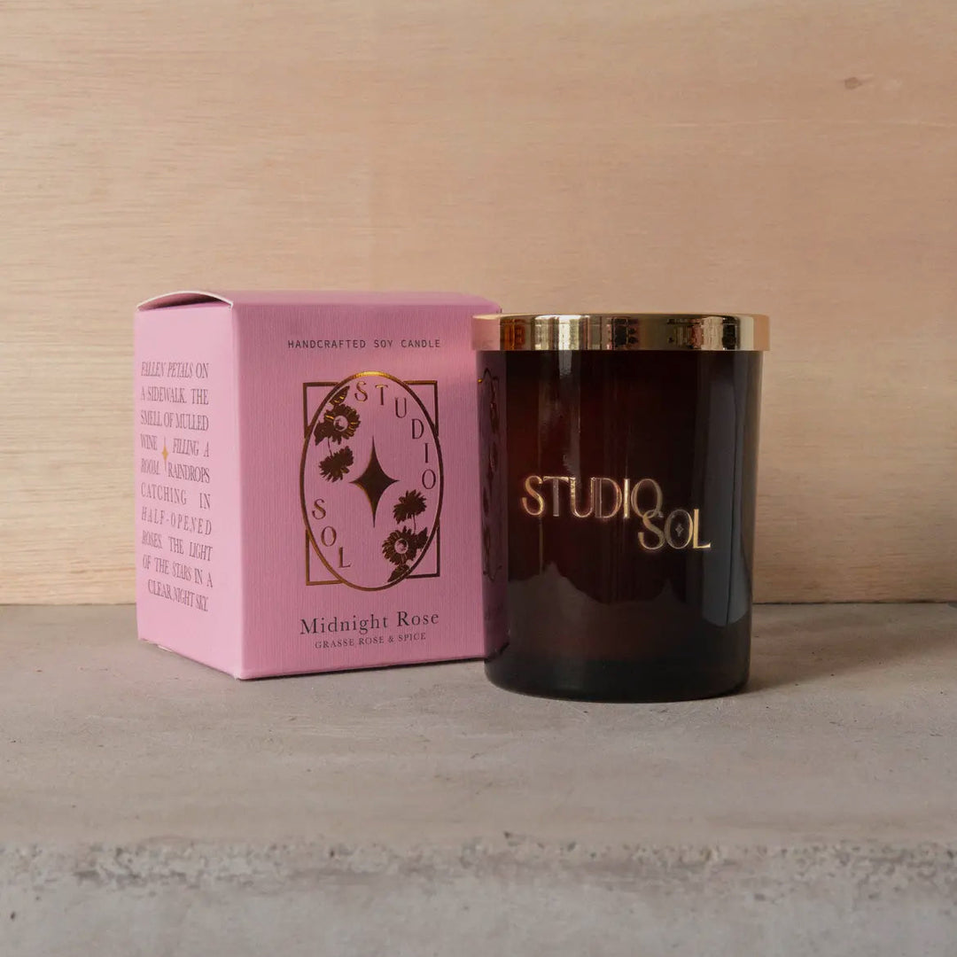 Studio Sol candle and packaging on a wooden surface