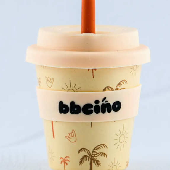 Beige cup with palm tree design and 'bbeeino' branding on a light blue background