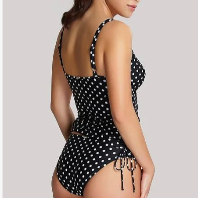 Black polka dot swimsuit with cutout sides on a plain background