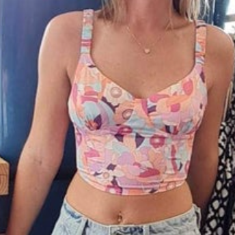 Person wearing a colorful patterned crop top with a blurred background