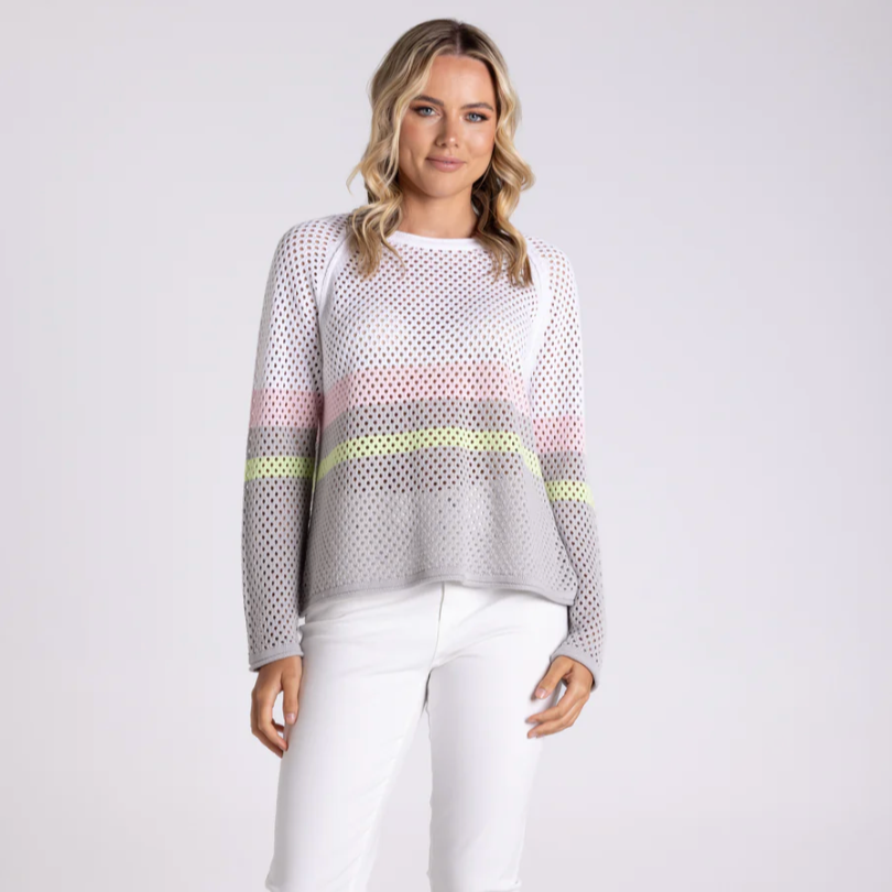 Woman wearing a patterned sweater with a gradient design on a white background