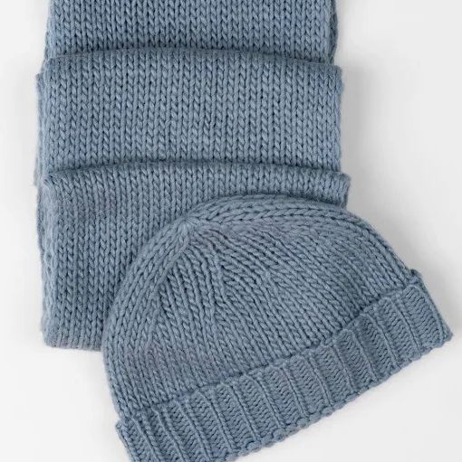 Blue knitted hat and scarf set on a white background