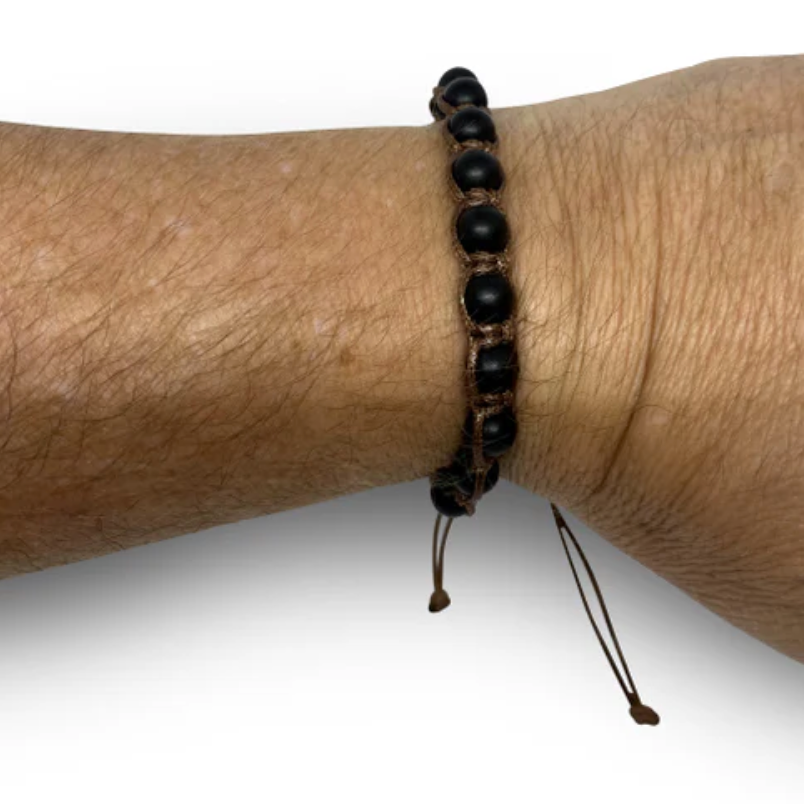 Black beaded bracelet on a wrist against a white background